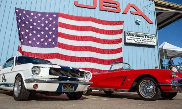 JBA Speed Shop headquarters with American flag and classic Mustangs